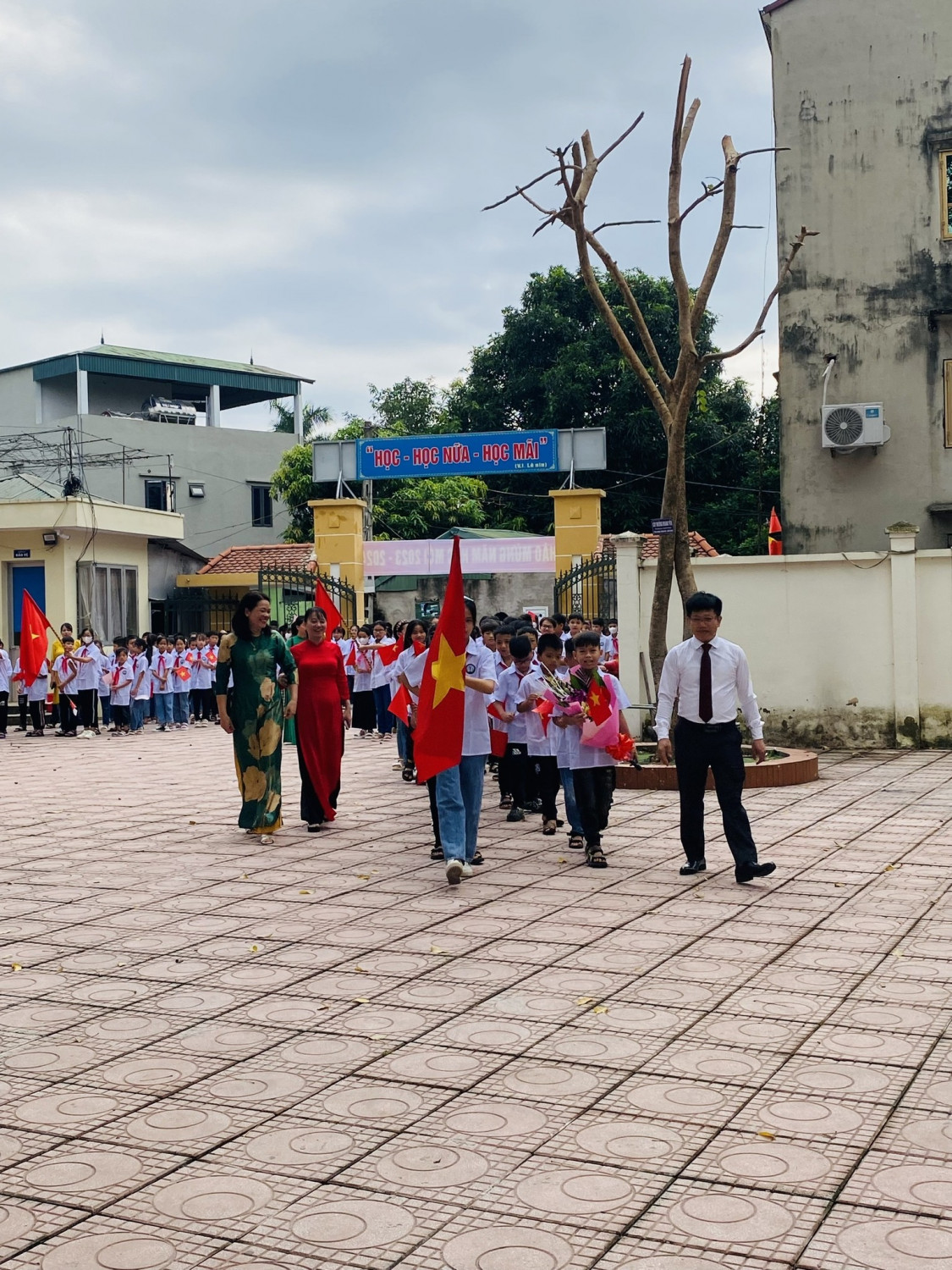 Thầy Trần Việt - Bí thư Chi bộ, Hiệu trưởng cùng các thầy cô giáo và đội danh dự đón học sinh lớp 6.